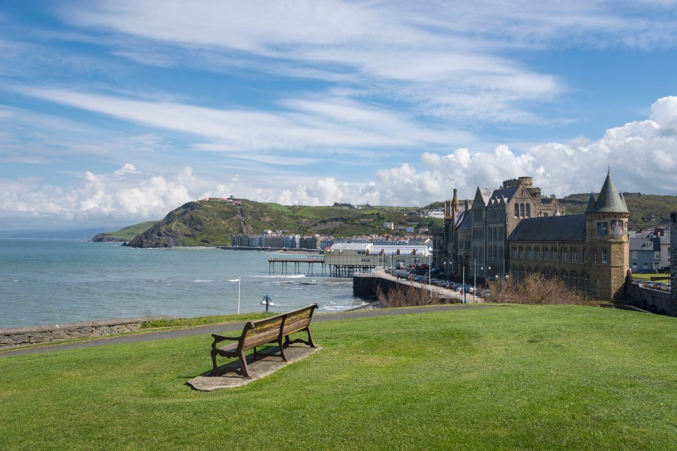 View from a castle of a promenade, university building, and pier in a seaside town.