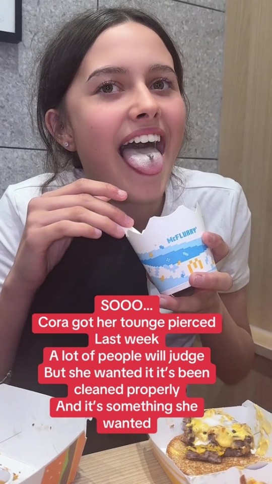 Teenage girl with a new tongue piercing.