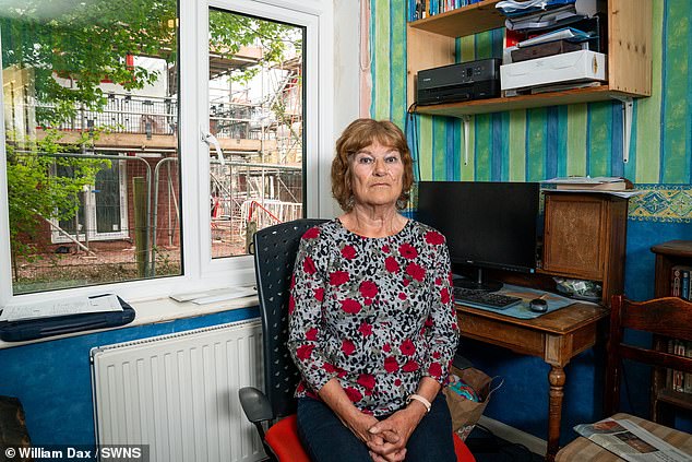 Martine pictured inside her study, which now has no natural light due to the building site