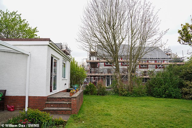 The couple returned home from a six-month holiday and saw two-storey houses built next to their bungalow.