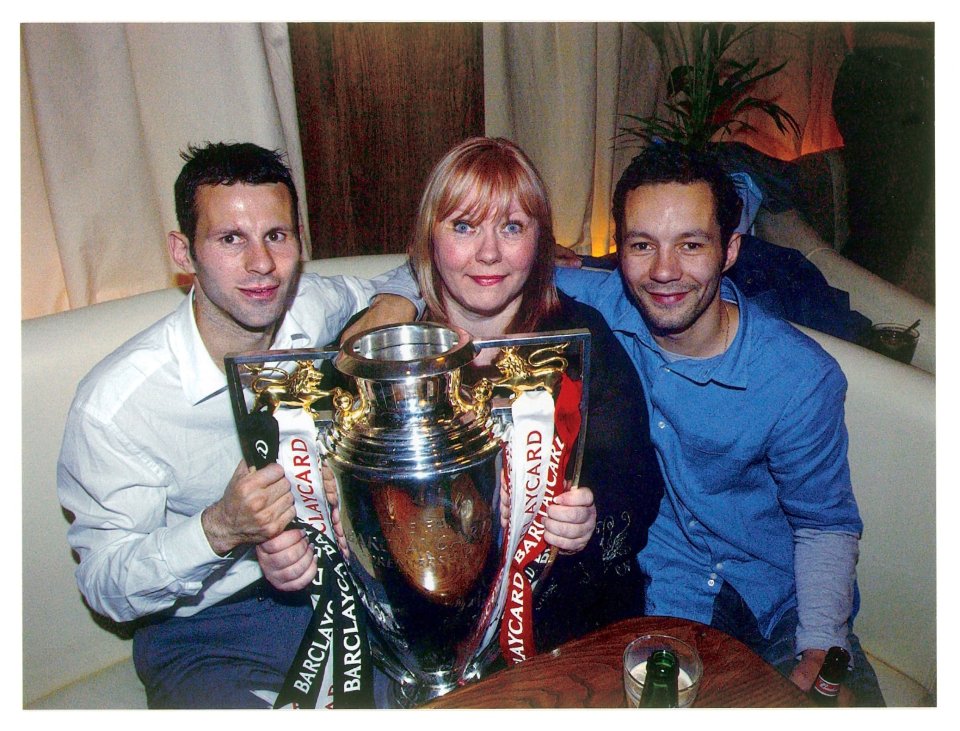 Ryan Giggs with his mother and brother holding a Premiership trophy.