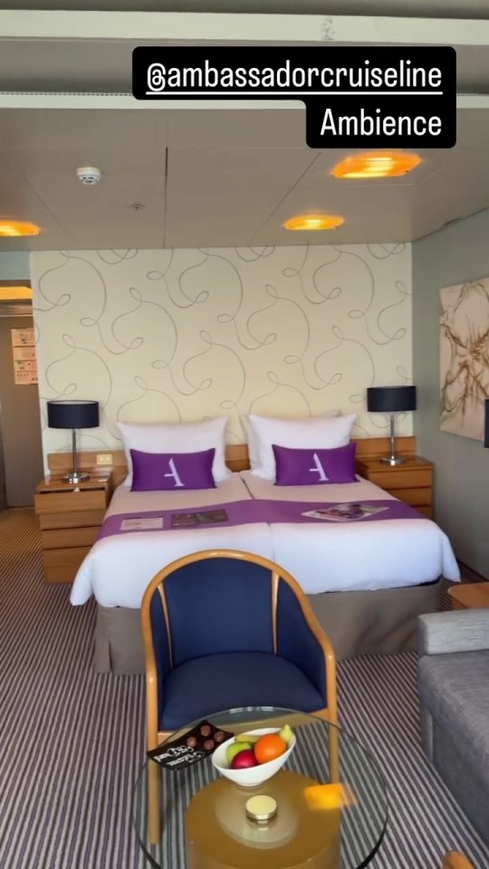 Ambassador cruise line suite with twin beds and sitting area.