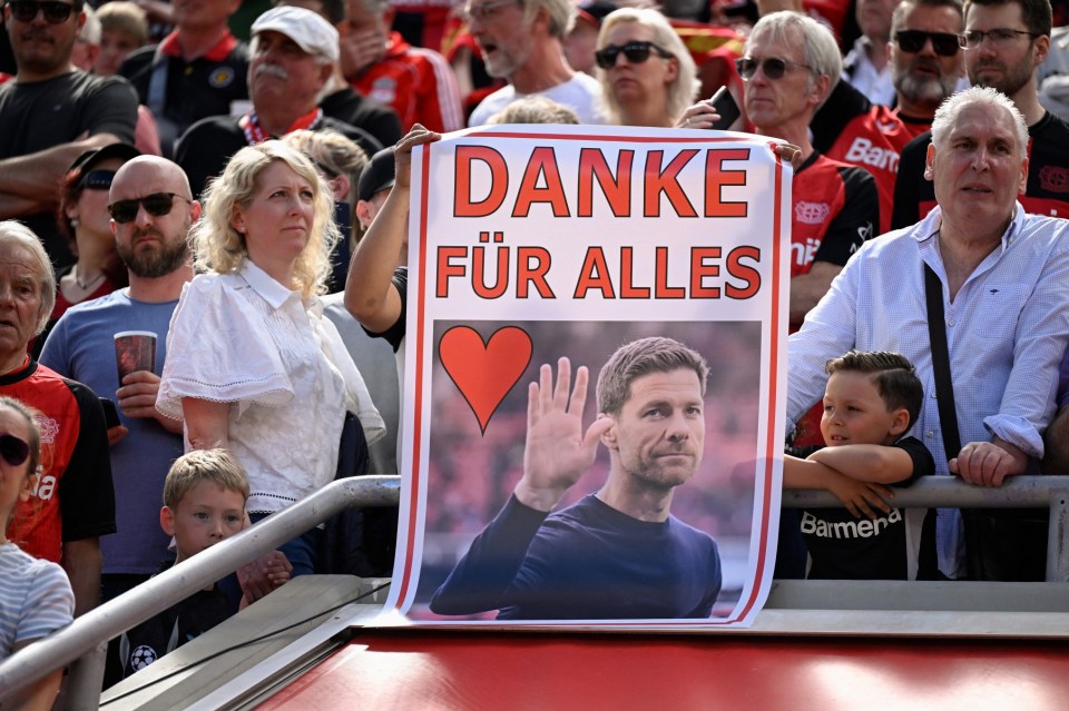 Bayer Leverkusen fans display a placard thanking Spanish head coach Xabi Alonso during the event marking his last home match prior to the German first division Bundesliga football match between Bayer 04 Leverkusen and Borussia Dortmund in Leverkusen, western Germany, on May 11, 2025. Bayer Leverkusen coach Xabi Alonso announced on May 9th he will leave the club at the end of the season, amid reports linking him to Spanish giants Real Madrid. Alonso said it was "the right moment" to announce the exit, but did not confirm his next post, saying it was "not the right moment to talk too much about the future". (Photo by INA FASSBENDER / AFP) / DFL REGULATIONS PROHIBIT ANY USE OF PHOTOGRAPHS AS IMAGE SEQUENCES AND/OR QUASI-VIDEO (Photo by INA FASSBENDER/AFP via Getty Images)