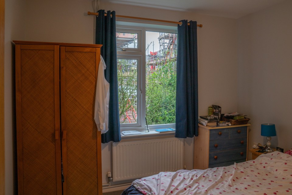Bedroom with a window overlooking construction.