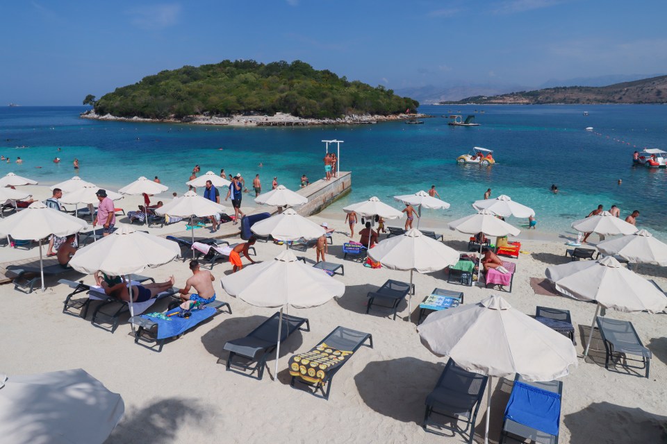 Beachgoers relaxing under umbrellas on a sunny beach.