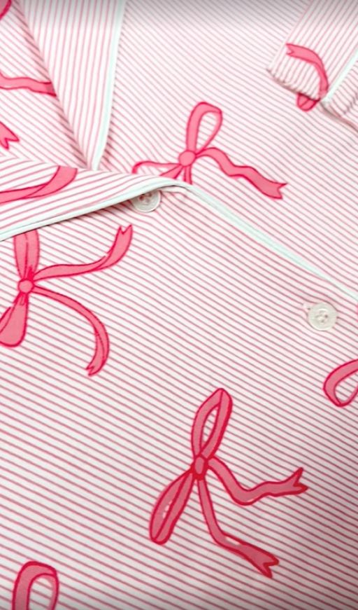 Close-up of pink striped pajamas with pink bows.