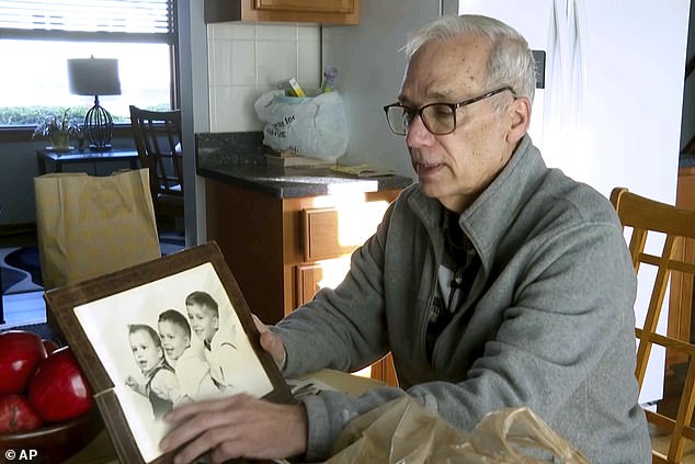 Pictured: John Prevost, brother of Pope Leo XIV, holds a portrait of the three Prevost brothers from 1958, Pope Leo, 3, left, John, 4, and Louis, 7, at his home Thursday, May 8, 2025