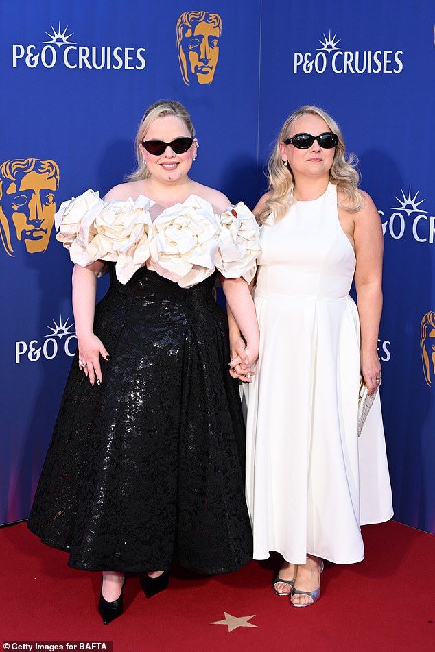 The duo put on a smitten display holding hands and then matching the same pair of edgy black shades