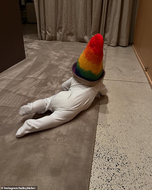 The little boy wore a cute onesie and a rainbow-colored cone-shaped hat in another sweet picture