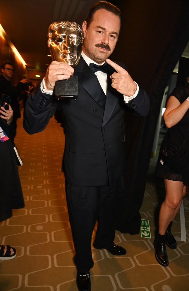 Danny Dyer holding a BAFTA award.