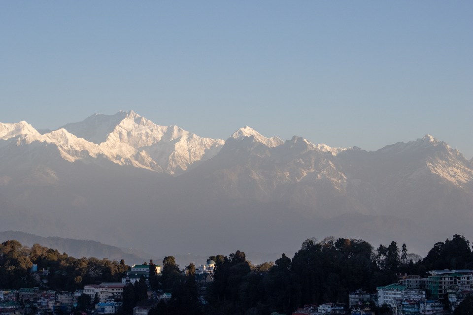 bright morning sun on Kanchenjunga mountain in the Himalayas taken from Darjeeling, India with the city in the foreground