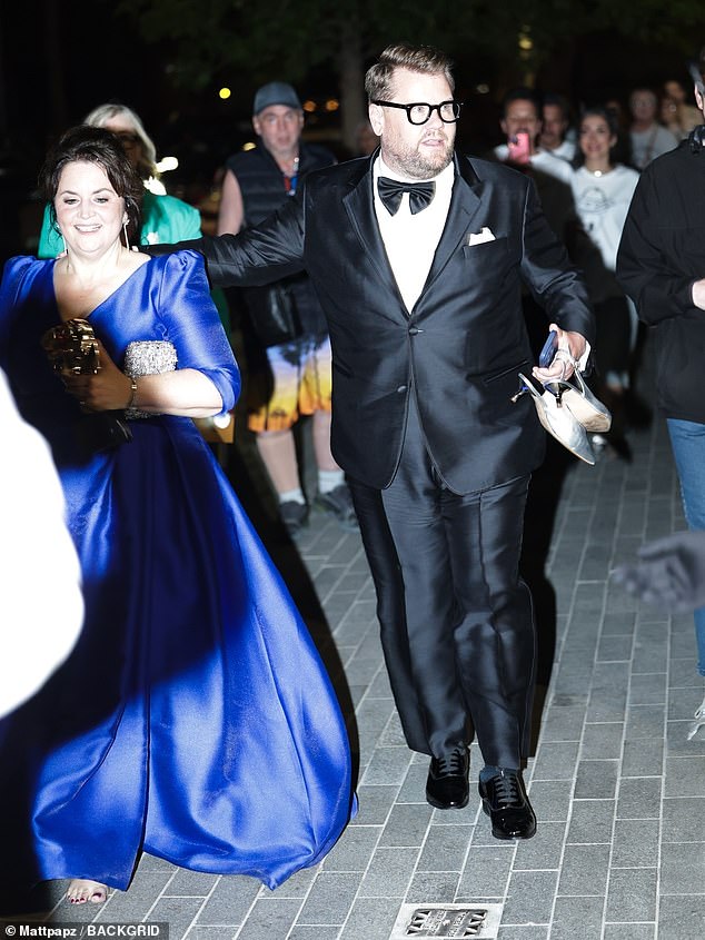 As Best Actress winner Ruth, 58, proudly carried her award as well as her bag, fellow writer James, 46, took charge of her silver footwear as they walked out together