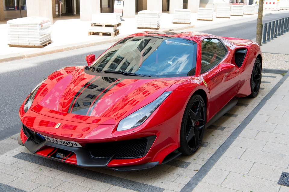 Red Ferrari 488 Pista parked on a city street.