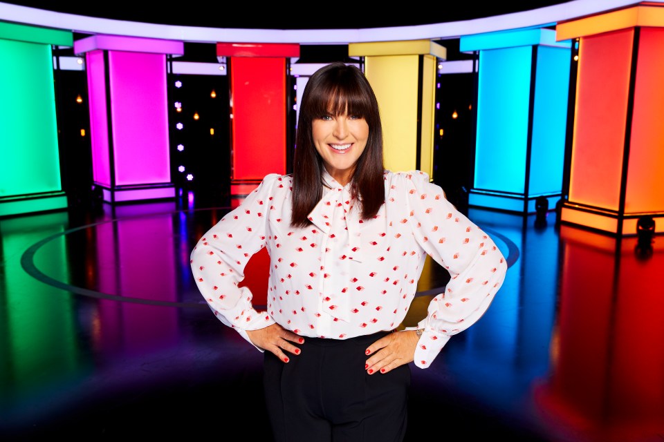 Anna Richardson posing in front of a colorful set.
