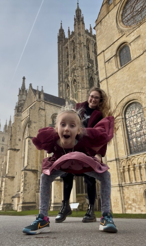 Two girls playing in front of a cathedral.