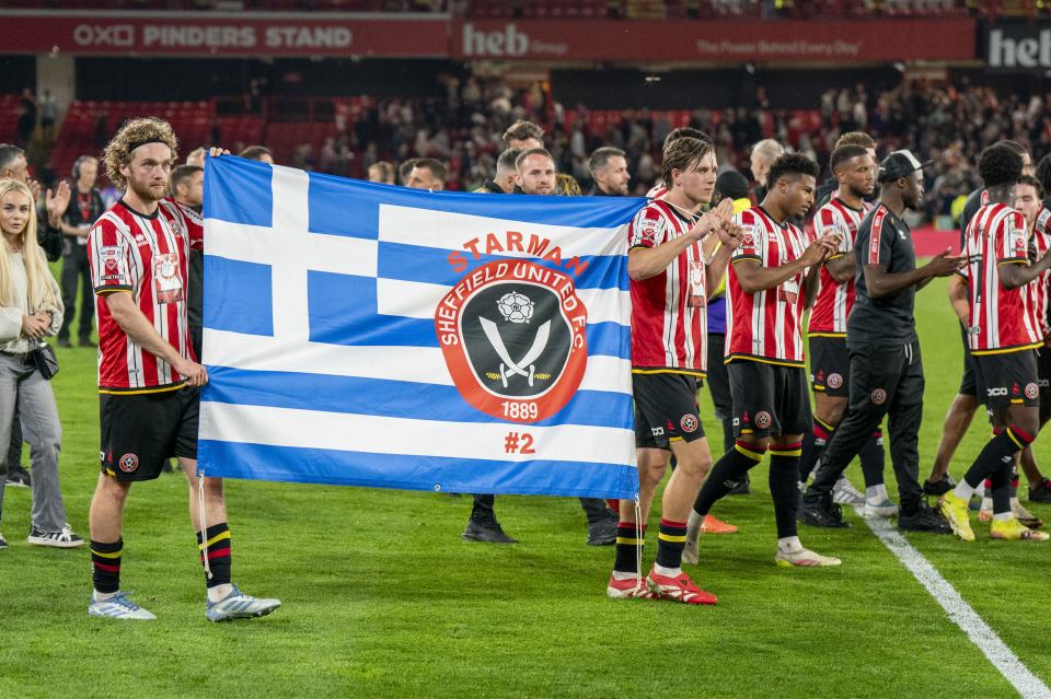 Sheffield United players holding a George Baldock banner.