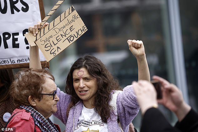 Activists hold placards as they demonstrate outside the Paris courthouse on the opening day of French actor Gerard Depardieu's trial