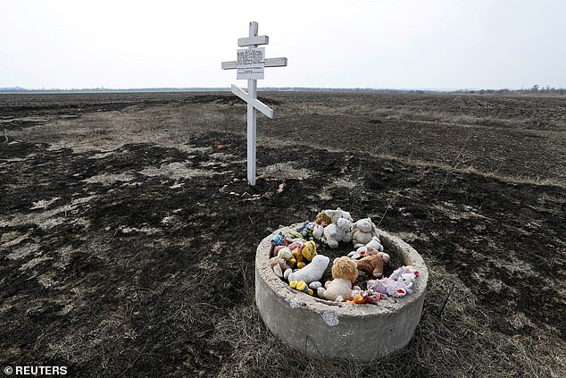 Toys are placed near the cross in memory of victims of Malaysia Airlines Flight MH17 plane crash in the village of Rozsypne in Donetsk region, Ukraine March 9, 2020