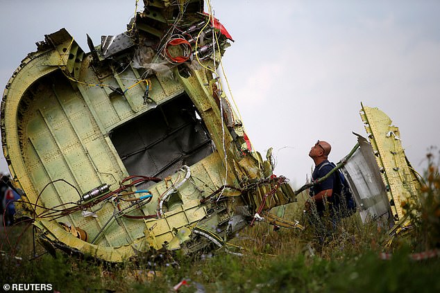 A Malaysian air crash investigator inspects the crash site of Malaysia Airlines Flight MH17, near the village of Hrabove (Grabovo) in Donetsk region, Ukraine, July 22, 2014