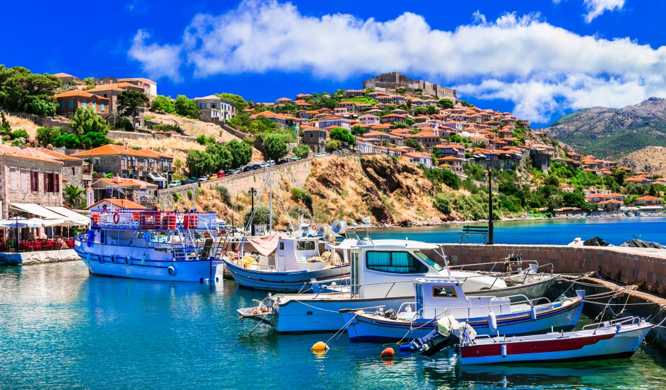 Mythimna (Molivos) harbor in Lesvos, Greece, with boats and a hilltop town.