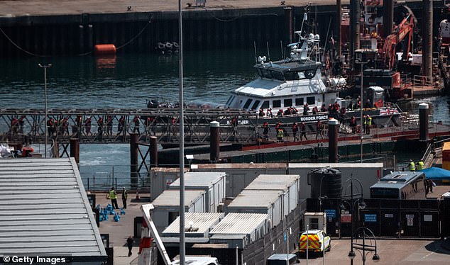 Illegal migrants disembark from a Border Force vessel into Dover port on May 12, 2025 in Dover, England