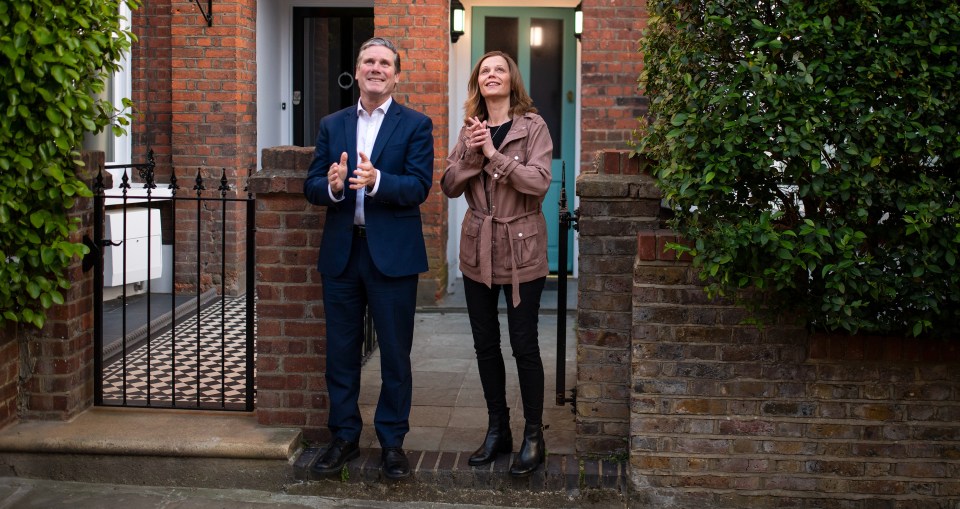 Keir Starmer and his wife applauding outside their home.