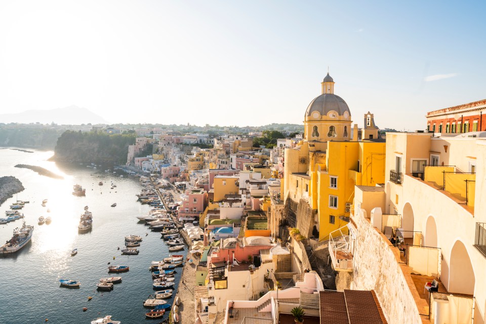 High-angle view of a colorful Italian coastal town with a harbor full of boats.