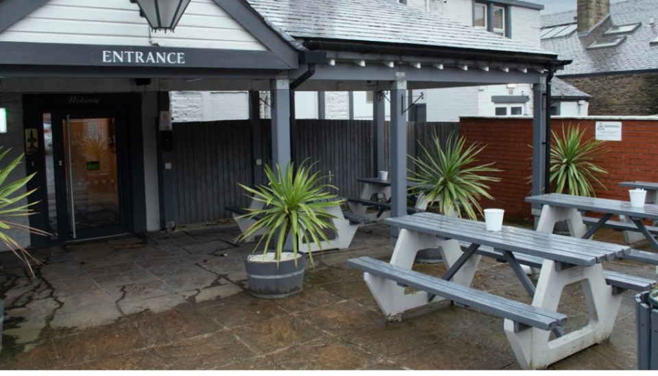Exterior of Hare & Hounds pub with picnic tables.