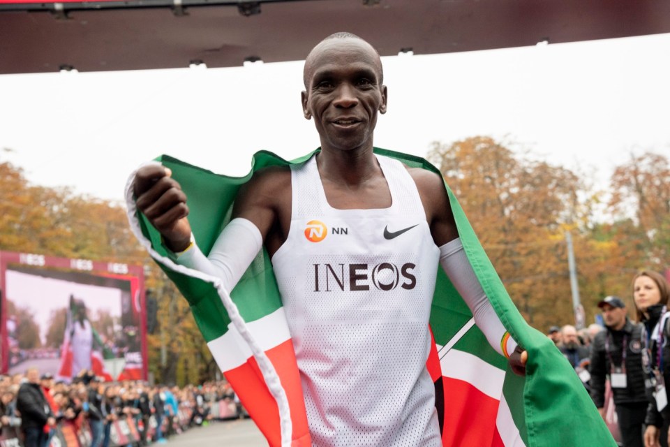 epa07914790 Eliud Kipchoge, Kenyan marathon world record holder, celebrates with the flag of Kenya in front of the finish line after the INEOS 1:59 Challenge in Vienna, Austria, 12 October 2019. Kipchoge attempted on the day to beat his own record becoming the first person to run a marathon distance under two hours, recording a time of 1 hour 59 minutes 40 seconds at the event. EPA/CHRISTIAN BRUNA EDITORIAL USE ONLY