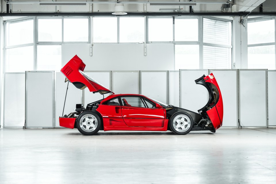 Red Ferrari F40 with engine compartment open.