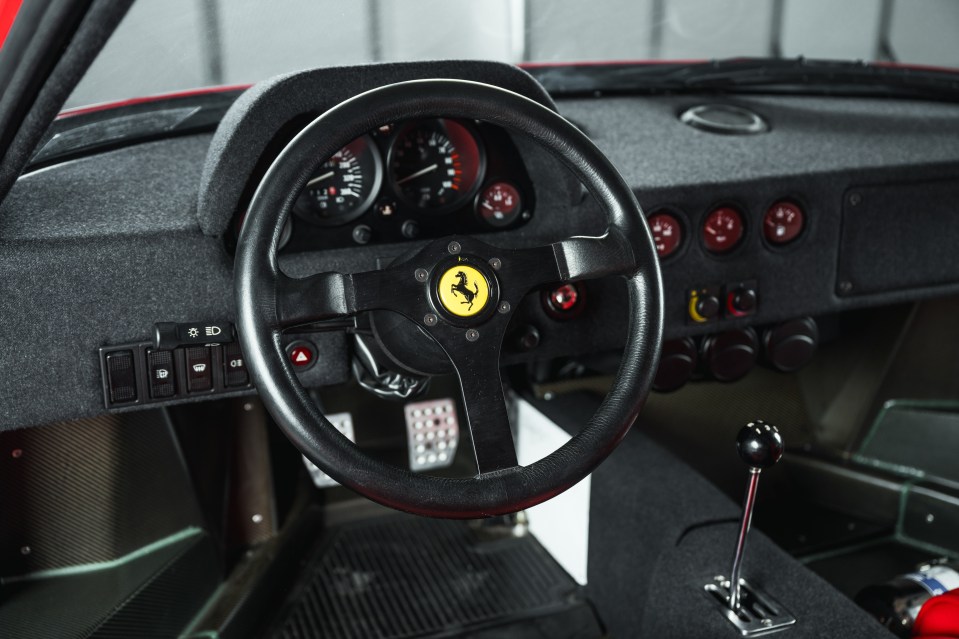 Close-up of a 1989 Ferrari F40's interior, showing the steering wheel and dashboard.