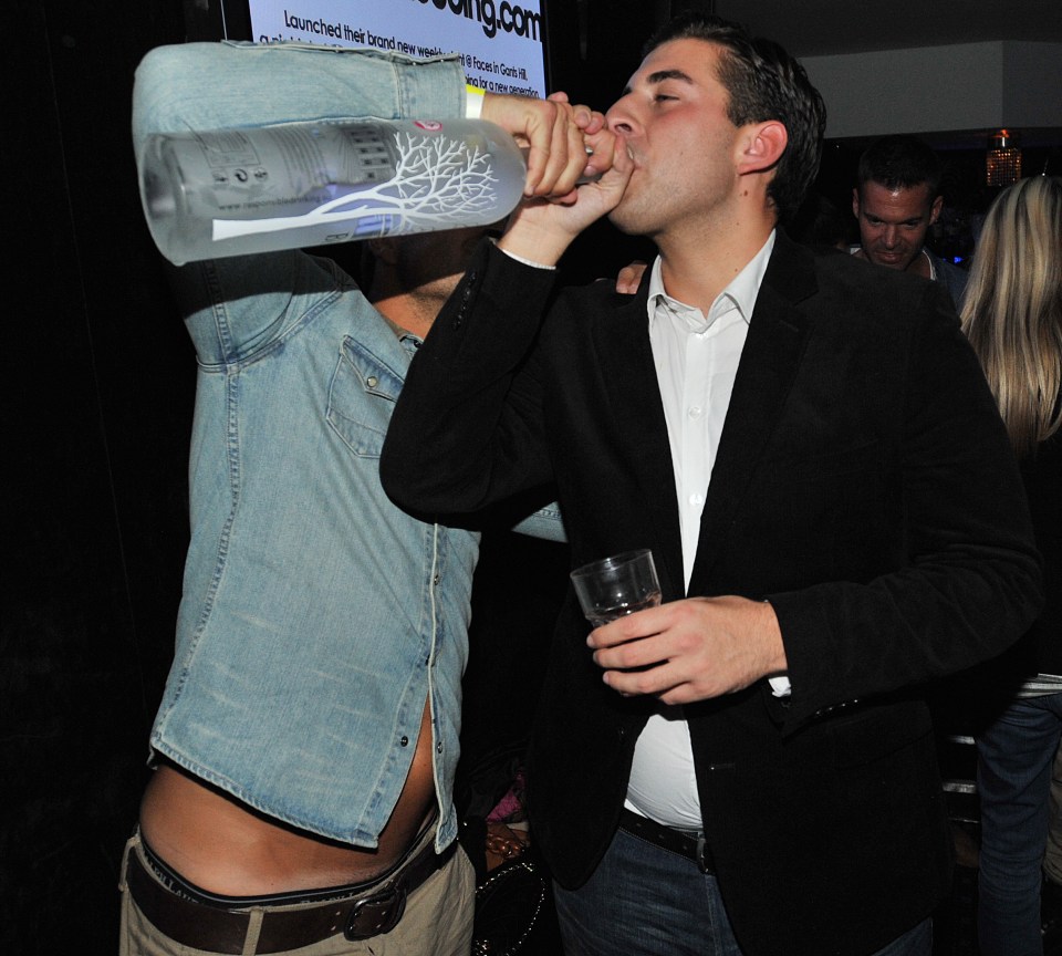 Two men drinking vodka at a nightclub.