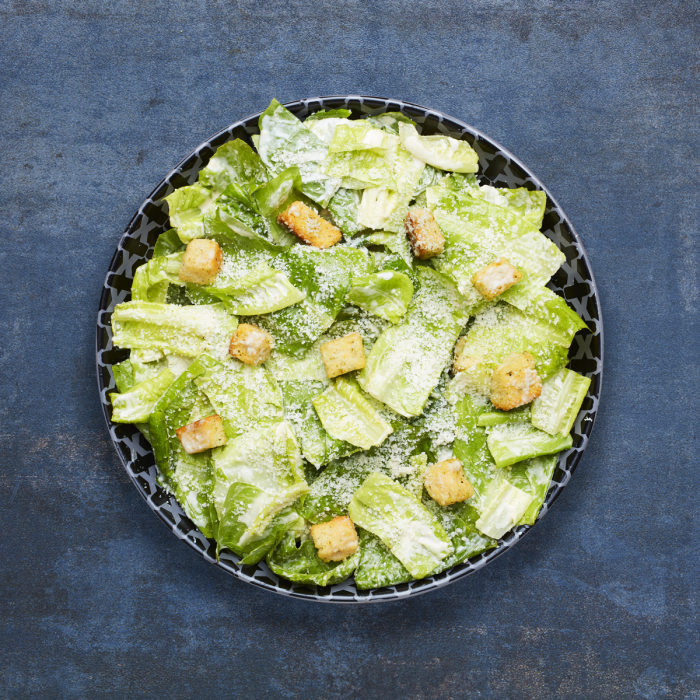 Caesar salad in a black bowl.
