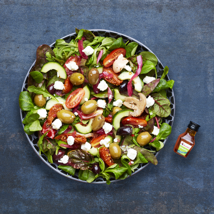 Mediterranean salad in a bowl with feta cheese, olives, cucumbers, and tomatoes.