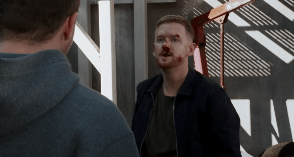 Screenshot of a man with a bloody nose speaking to another man.