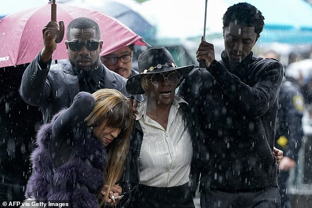 King Combs (R), son of Sean Combs, holds an umbrella for Janice Combs, mother of Sean Combs, as they arrive at federal court on Wednesday where Ventura continued her explosive testimony