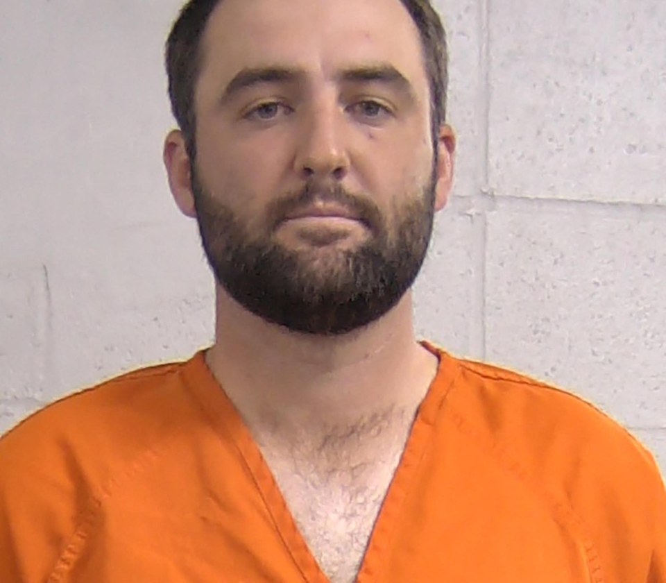 Mugshot of Scottie Scheffler in an orange jumpsuit.