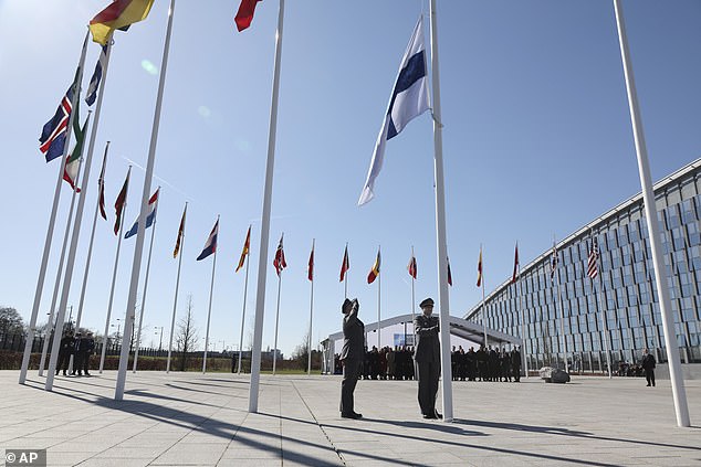 Military personnel raise the flag of Finland during a flag raising ceremony after the country's accession to the military alliance in April 2023