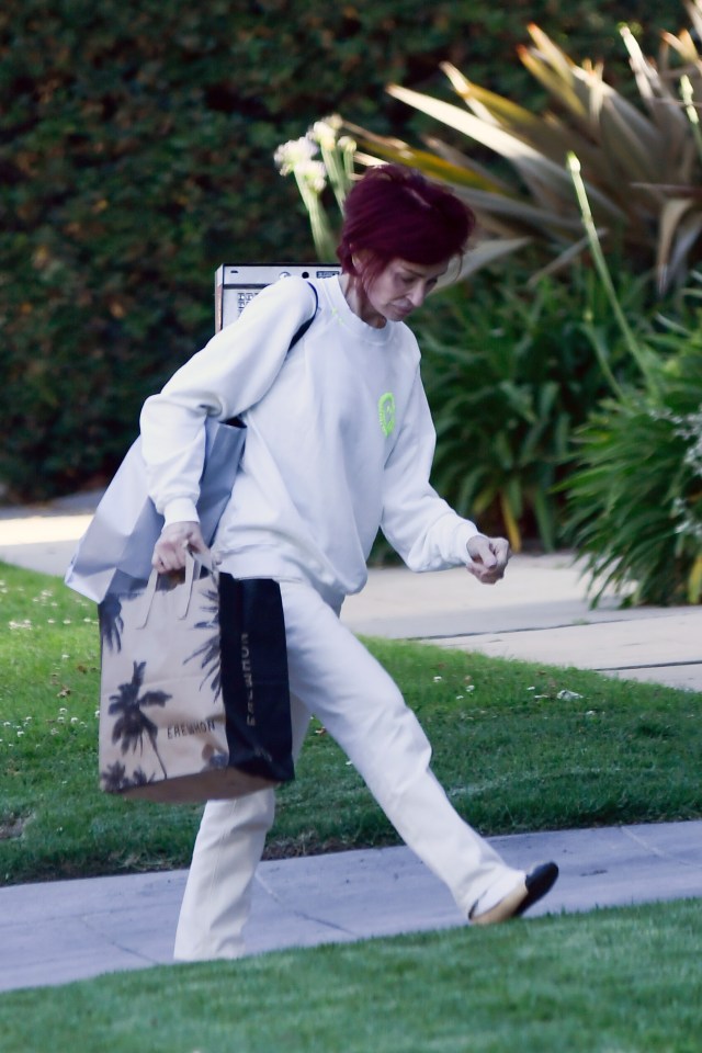 Sharon Osbourne walking and carrying shopping bags.