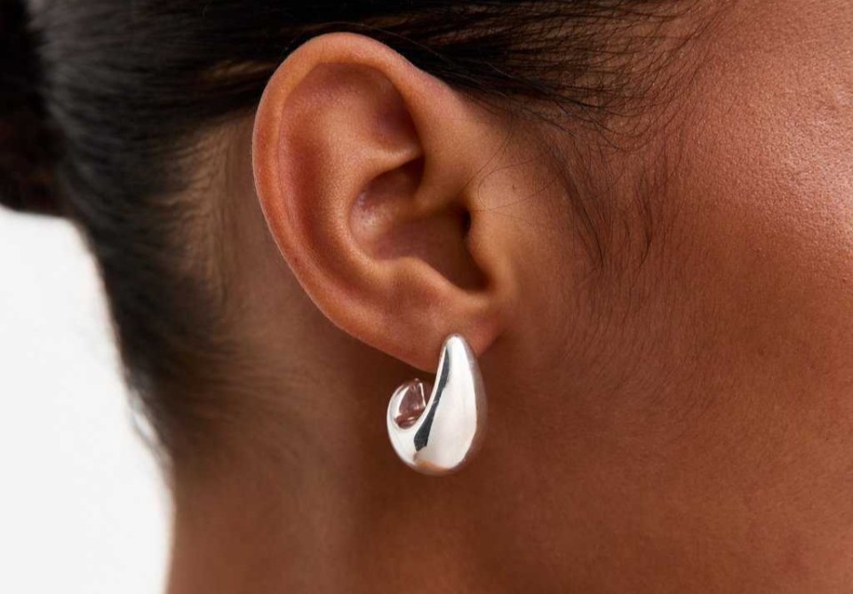 Person wearing silver hoop earrings.