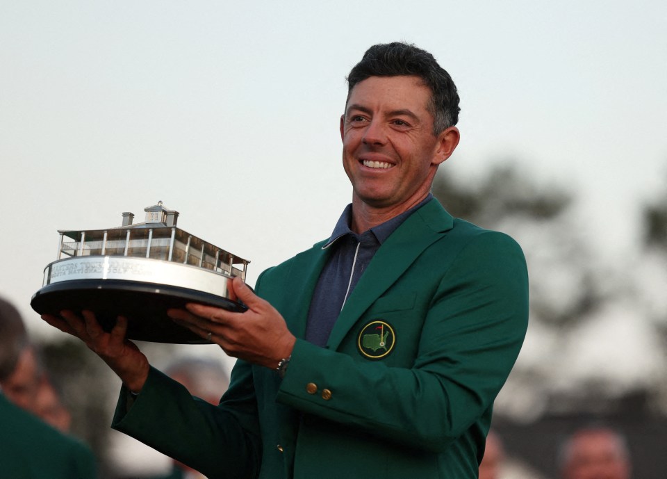 Rory McIlroy holding the Masters Tournament trophy and wearing the green jacket.