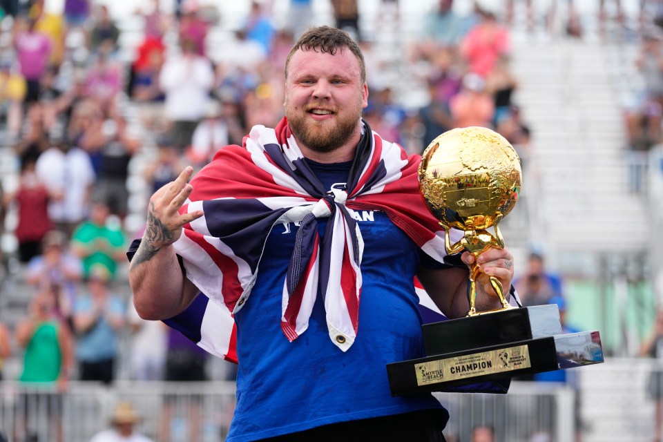 Tom Stoltman, World's Strongest Man, holding his trophy.