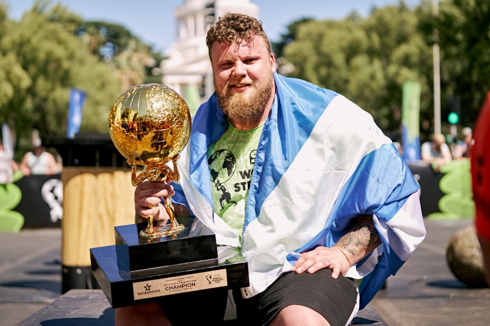 Tom Stoltman, World's Strongest Man 2022, holding his trophy.