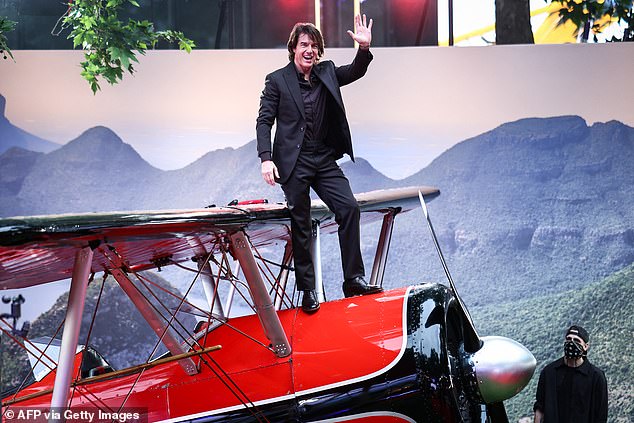 Not missing the opportunity for a stunt, Tom made sure to climb on top of a red plane on the red carpet to wave at fans from above