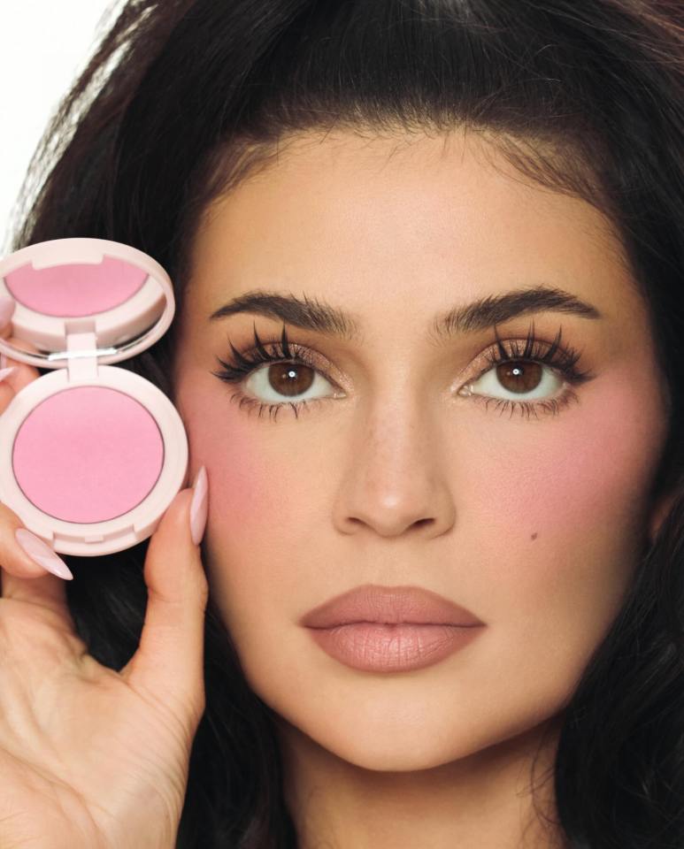 Woman holding blush compact.