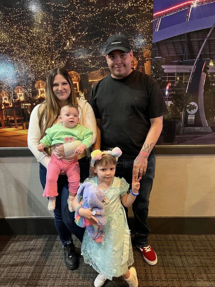 Family photo of a mother, father, baby, and toddler.