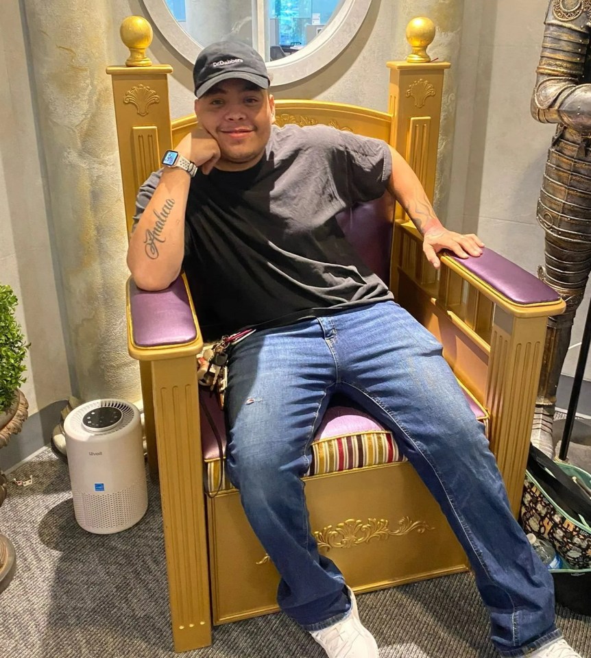 Man sitting in a gold chair.