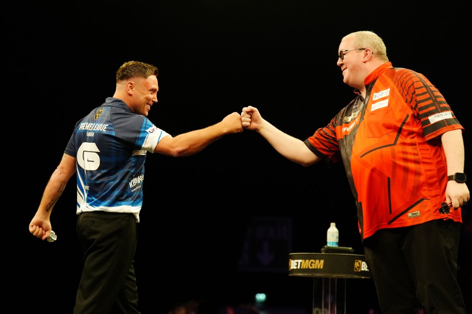Gerwyn Price and Stephen Bunting fist-bumping after a darts match.