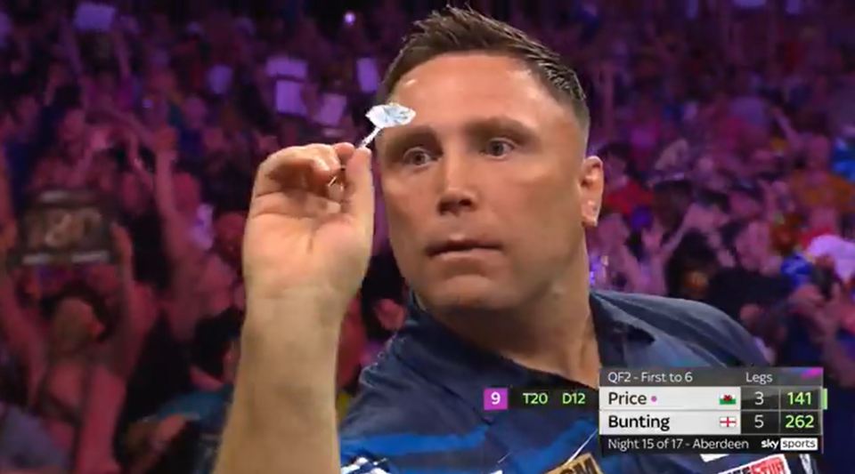 A darts player aiming at the board.