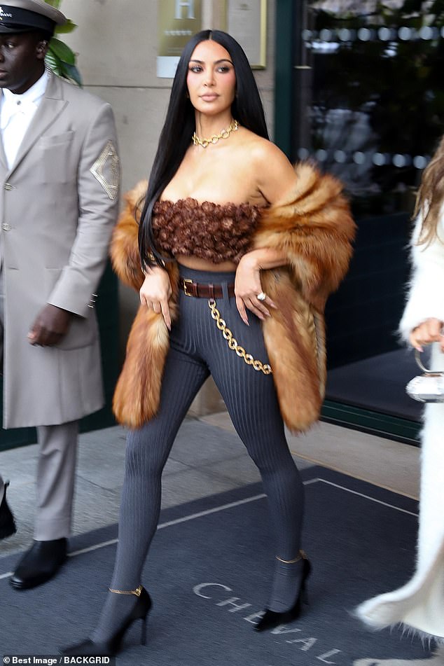 Kim flashed her toned midriff in a bandeau top and high-waisted dark grey leggings that showed off her hourglass curves